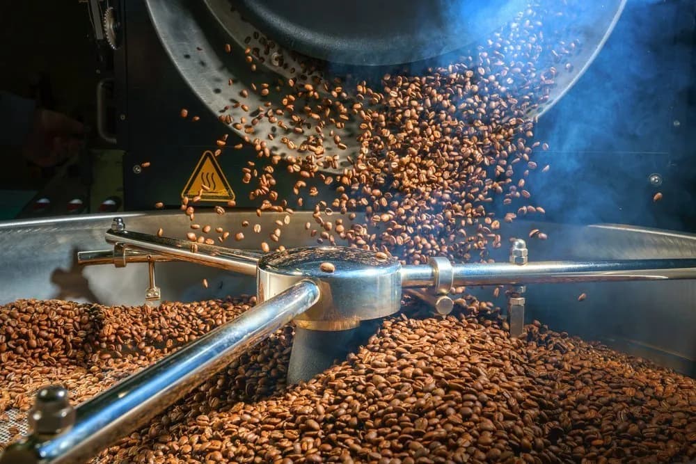 Granos de café cayendo del tostador